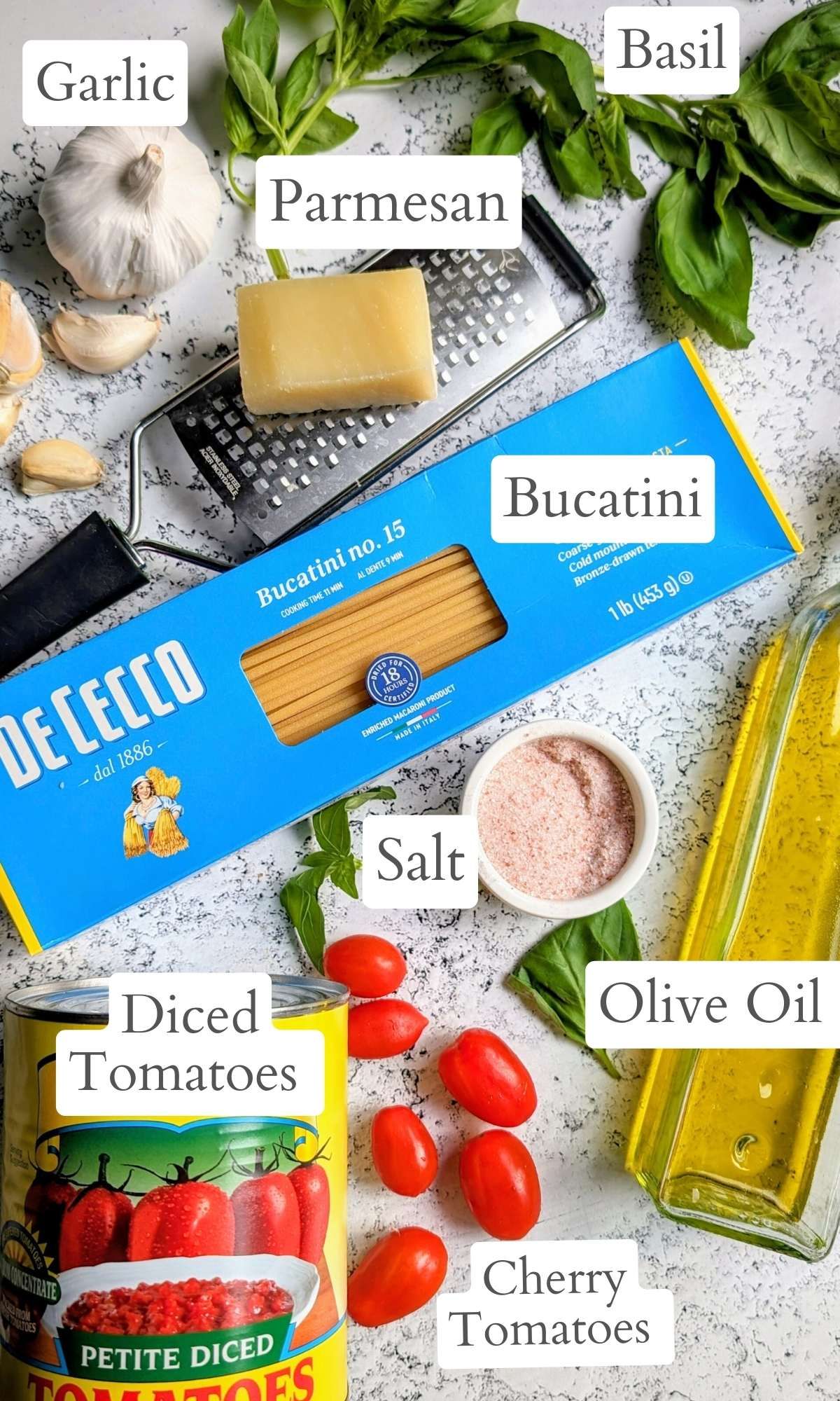 ingredients for bucatini pomodoro sauce pasta like cherry tomatoes, canned diced tomatoes, salt, olive oil, fresh basil, and parmesan cheese.