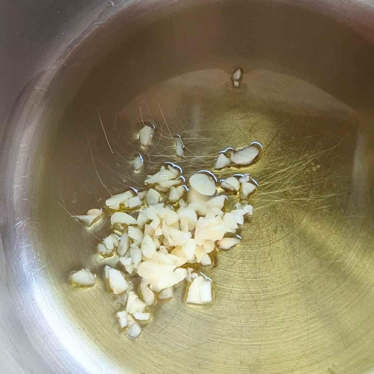 a pan with hot olive oil and fresh chopped garlic.