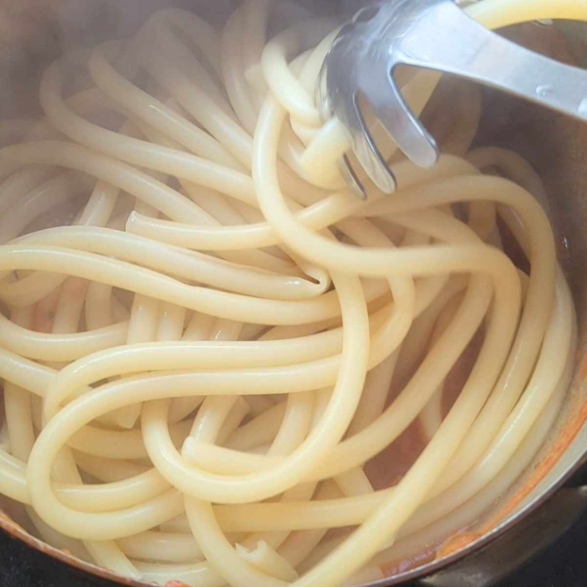 cooked bucatini pasta recipe in a pot ready for sauce.